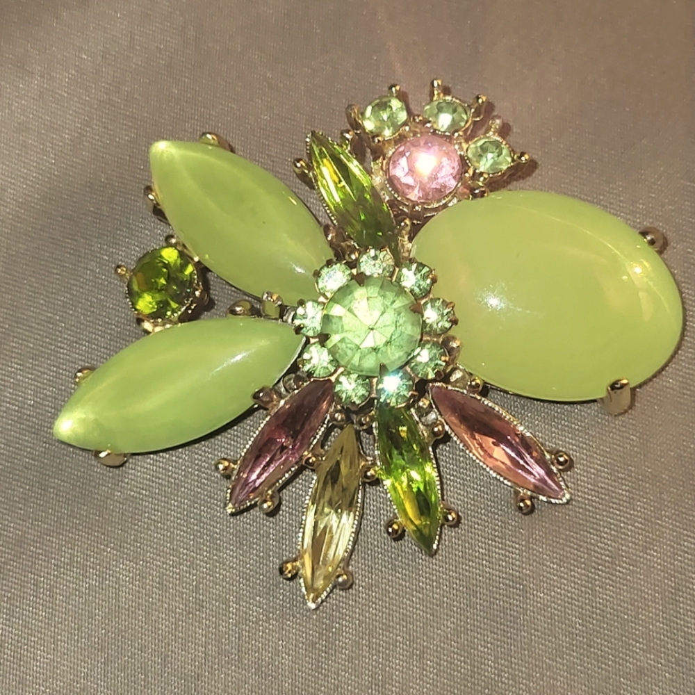 Brooch green and pink stones/gems with gold tone pin on back.